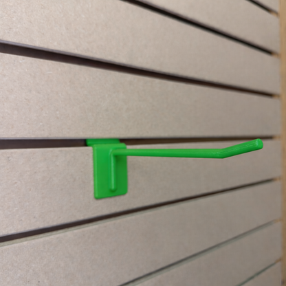 Ironleaf 6″ slatwall hook heavy duty reinforced polymer attached to a slatwall panel in bright green color.