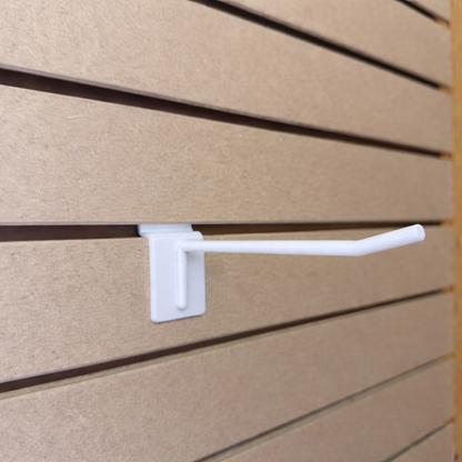 Ironleaf 6" slatwall hook heavy duty reinforced polymer mounted on slatwall panels for displaying products.