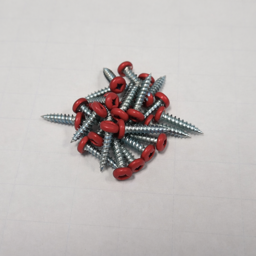 Color matched pan head screws robertson drive in a pile on a flat surface, highlighting the red pan heads.